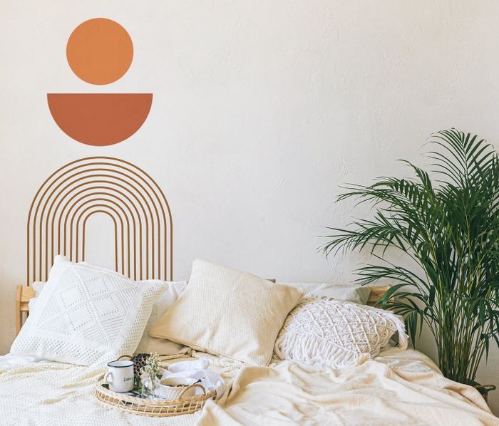 A modern wall decal creating a stunning backdrop behind a bed, effortlessly elevating the room’s aesthetic.