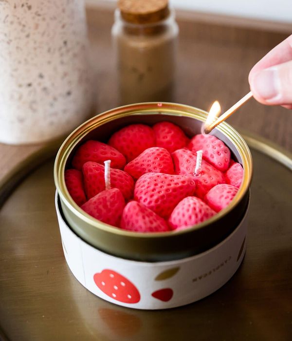 A canister with a soy wax candle designed to look like a tin of strawberries