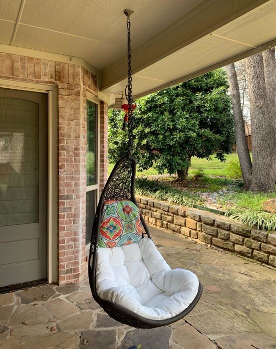 A reviewer's photo shows the wicker chair gracefully hanging under a covered patio, enhancing the outdoor ambiance.