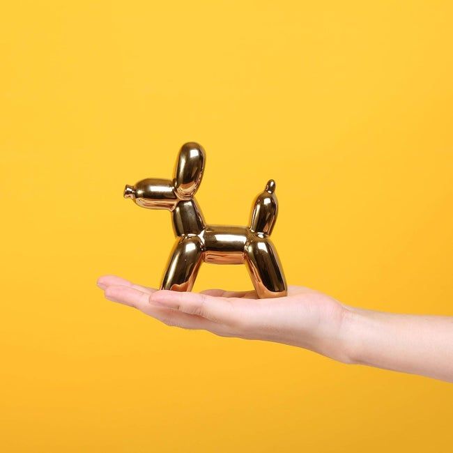 hand holding up a tiny balloon dog decoration