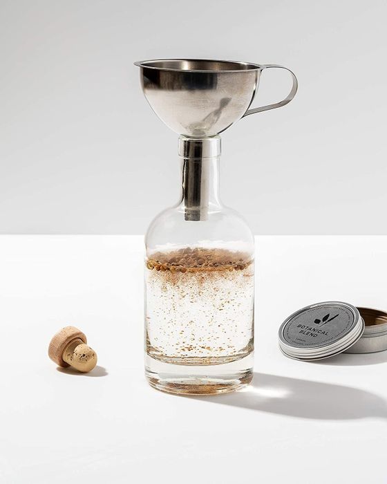 Bottle of gin and the tools from the kit used to create homemade gin