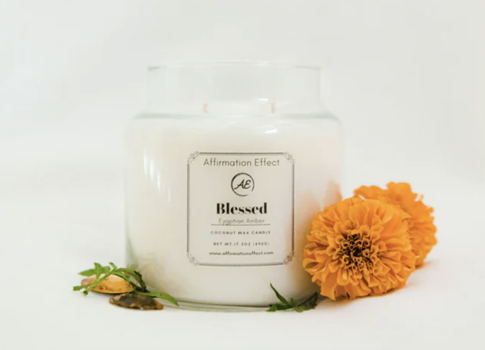 A candle accompanied by a flower is featured in the image.