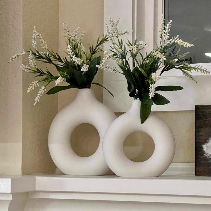 The vases placed on a mantle, adorned with flowers