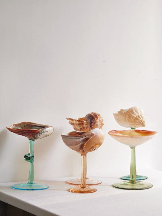 Six wine glasses with shell-topped bases, each featuring different colored stems.