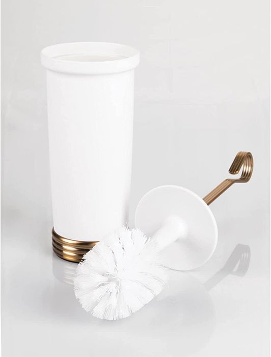 The toilet brush positioned next to its holder.