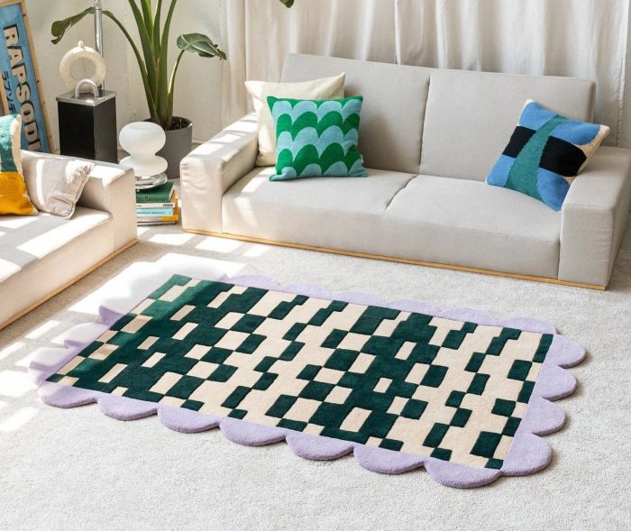 A green checkered rug featuring a purple scalloped edge, adding a playful yet stylish touch to any room.