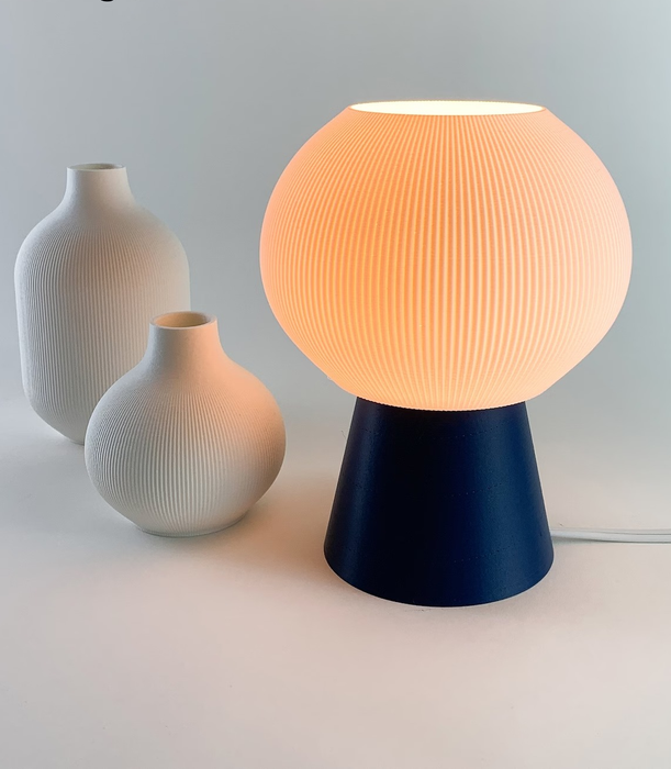 The glowing blue lamp, placed next to two elegant vases.