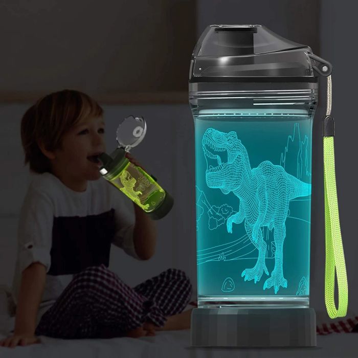 A child drinking from a glowing green dino cup next to a teal illuminated water bottle