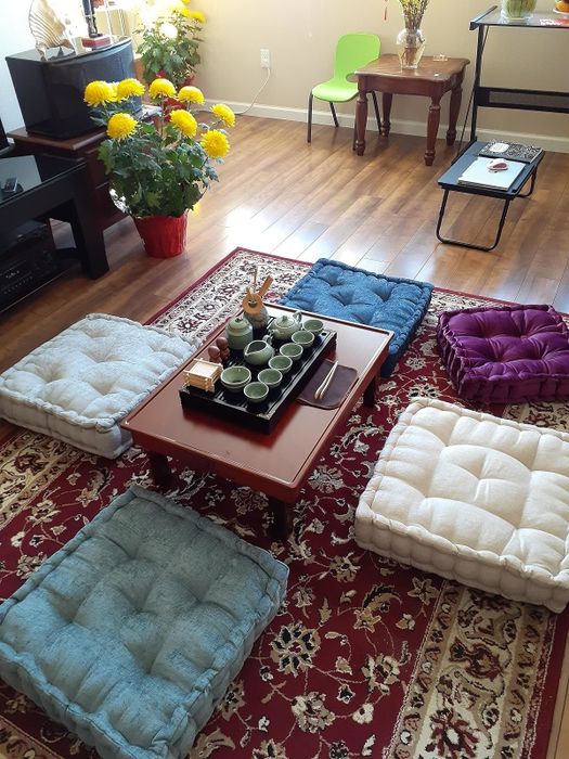 A user's living room featuring a traditional floor seating setup with a tea set placed on a wooden table