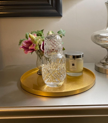 reviewer's carafe on a tray next to a candle and flowers