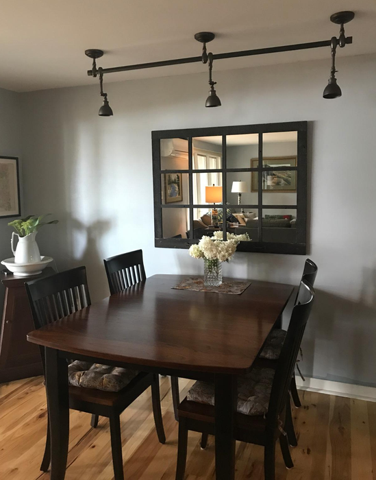 A reviewer’s photo of the black windowpane mirror hanging in their dining room.