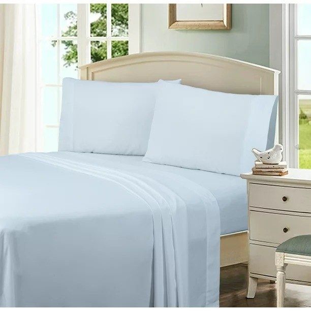 A white pillowcase set placed on pillows atop a neatly made bed