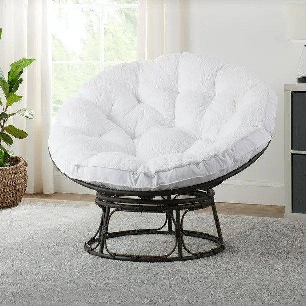 A white Papasan chair on a gray carpet.