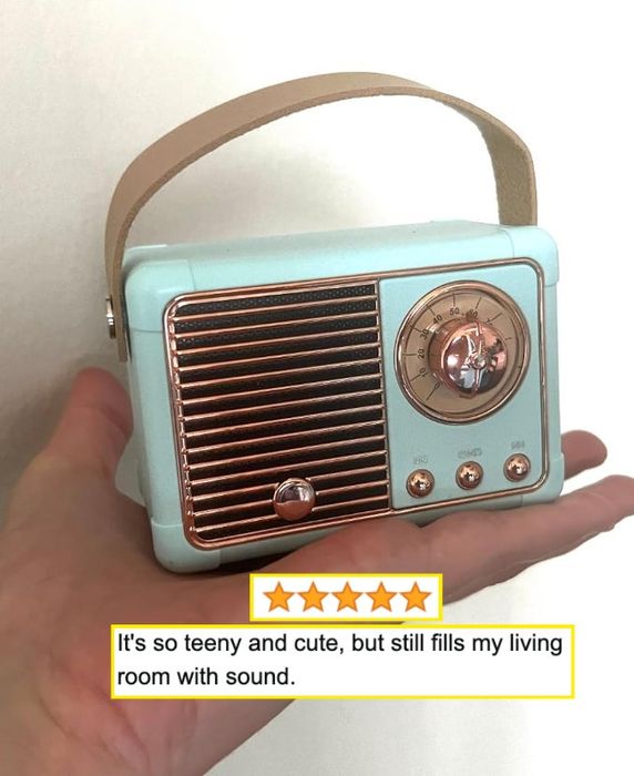 A reviewer joyfully holding a vintage-style mini radio, impressed by its impressive sound quality.