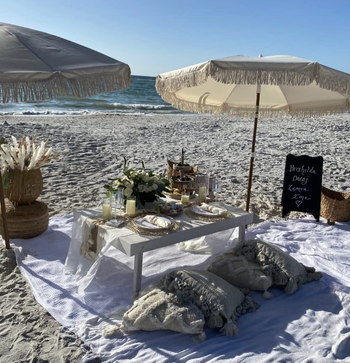 The white version of the umbrella set up on a beach