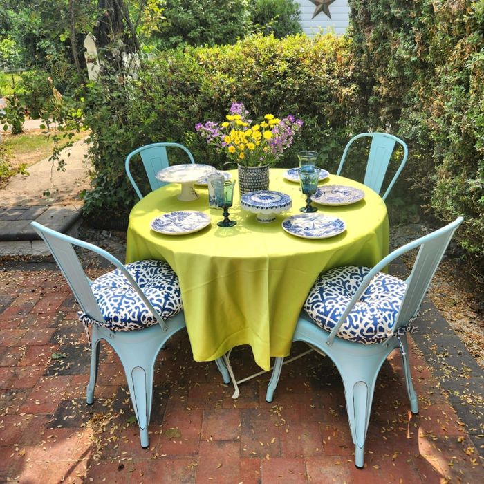 A reviewer’s outdoor dining arrangement, complete with tableware and flowers set on a garden patio table, offering home decor inspiration.