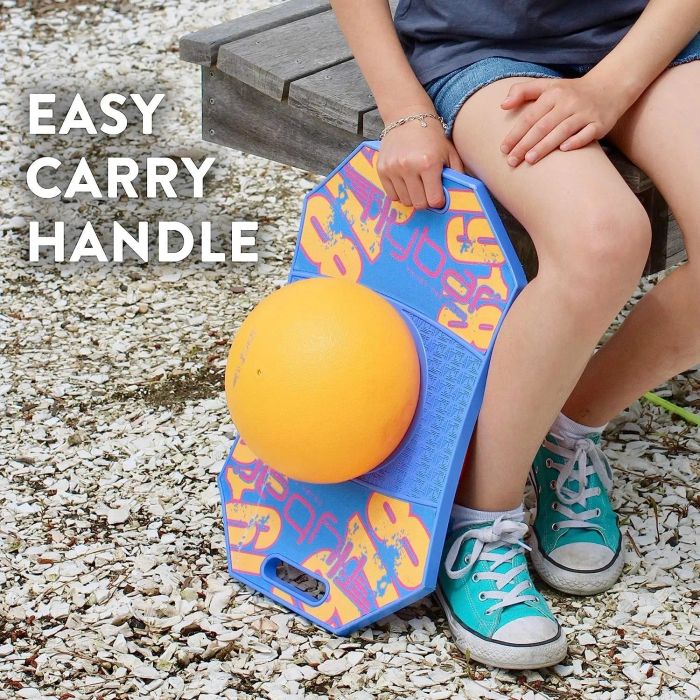 A child model holding a blue and orange pogo ball by the handle