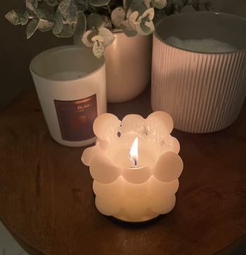 A white candle burning, revealing the melting wax inside