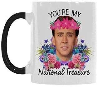 a coffee mug featuring Nicolas Cage’s face adorned with flowers and text