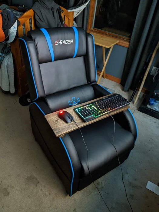 Gaming recliner with a tray holding a keyboard and mouse