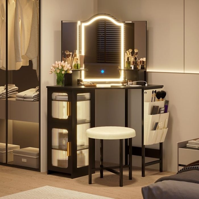 Contemporary vanity setup with a lighted mirror, neatly arranged makeup brushes, a round stool, and storage shelves in a chic dressing area