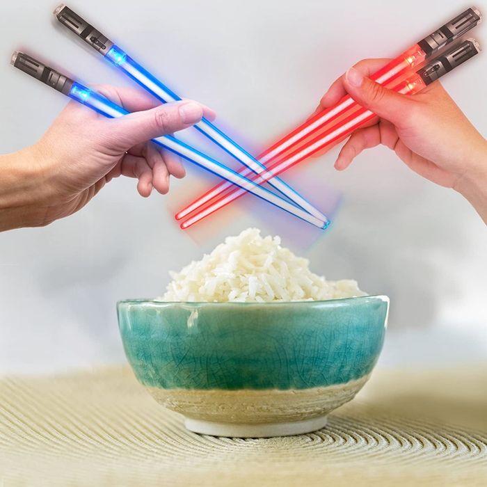 Two sets of glowing lightsaber chopsticks in blue and red hues.