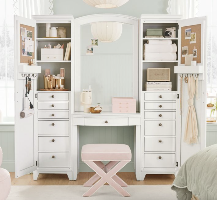 A neatly arranged vanity with shelves and drawers, showcasing makeup, a sewing machine, and towels. Perfect for those passionate about beauty or crafting