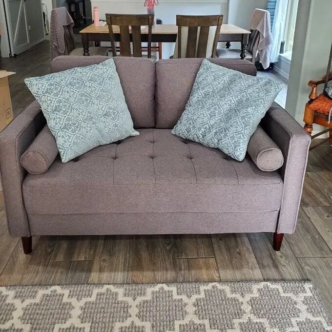 A customer photo showing the gray version of the couch