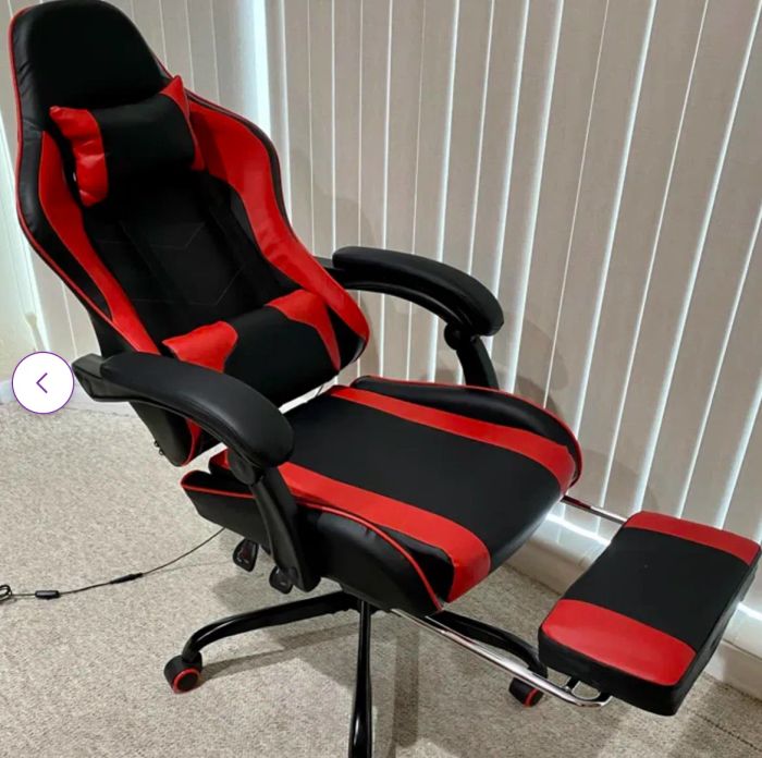 Ergonomic gaming chair with adjustable armrests and leg rest in a modern office setting