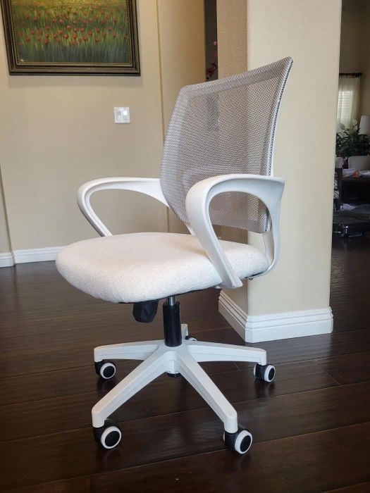 Office chair featuring a mesh backrest and cushioned seat, mounted on swivel wheels, suitable for both home and professional environments