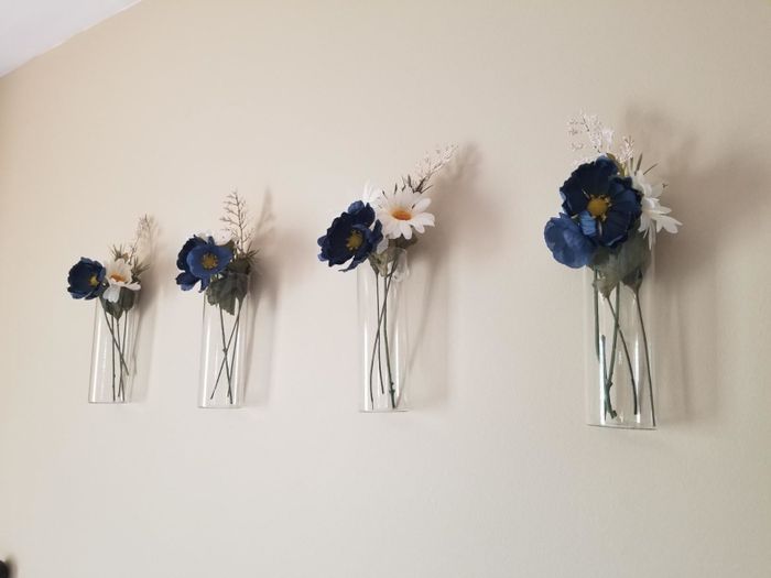 A reviewer’s photo featuring four sets of blue and white flowers elegantly displayed in cylindrical vases.