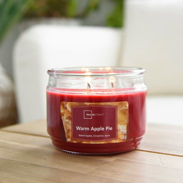 A deep red candle housed in a sleek glass jar, evoking the essence of warm apple pie.