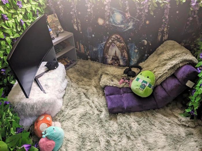A cozy gaming nook featuring a curved monitor, soft seating, a plush rug, and charming, whimsical decor