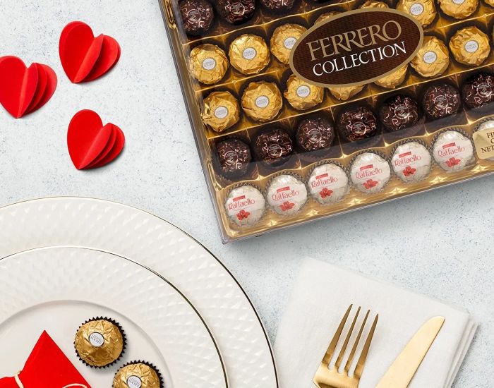 The 48-piece Ferrero Rocher Collection variety pack displayed next to some elegant plates.