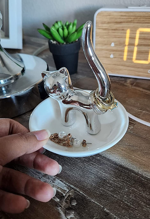 A hand holding the charming cat-shaped trinket dish.