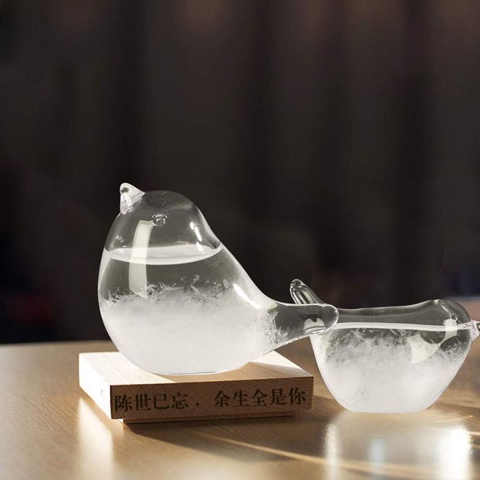 A glass bird-shaped weather predictor on display.