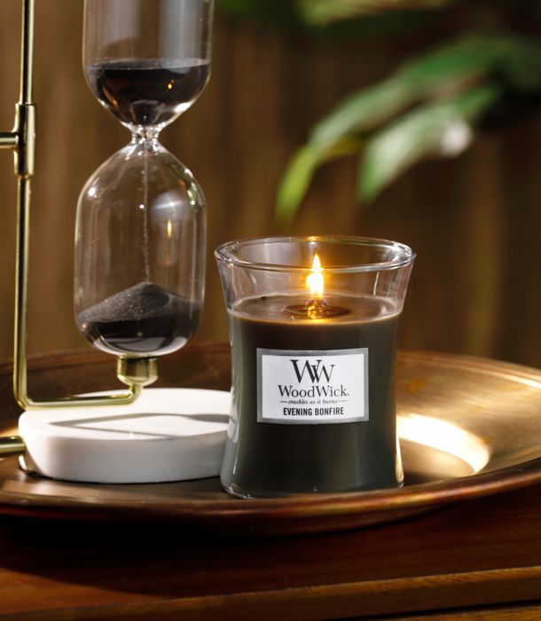 A sleek glass jar encasing the evening bonfire WoodWick candle, ready to enhance your space with its unique, crackling ambiance.
