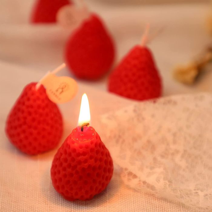 A red version of the candles with one lit, showcasing its glow 