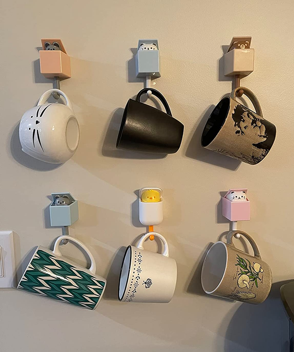 the hooks being used to hang six mugs on a wall