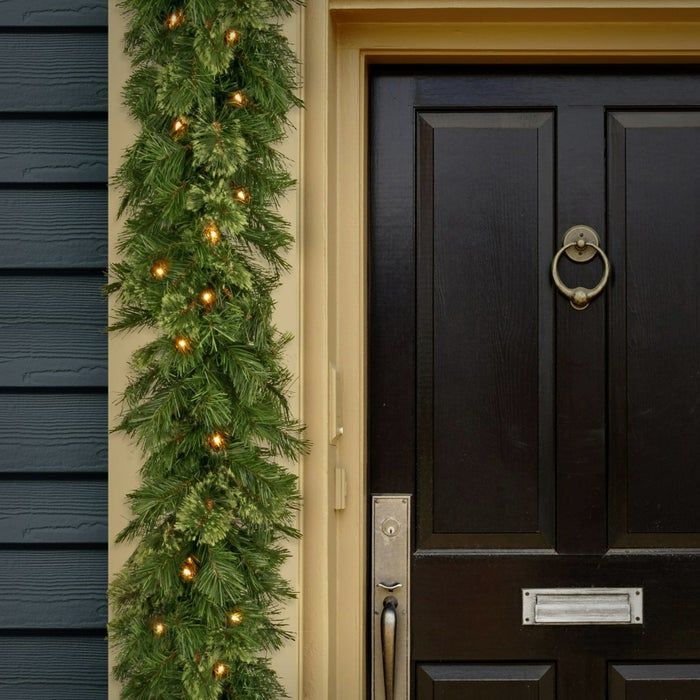 a green pre-lit garland framing a front door