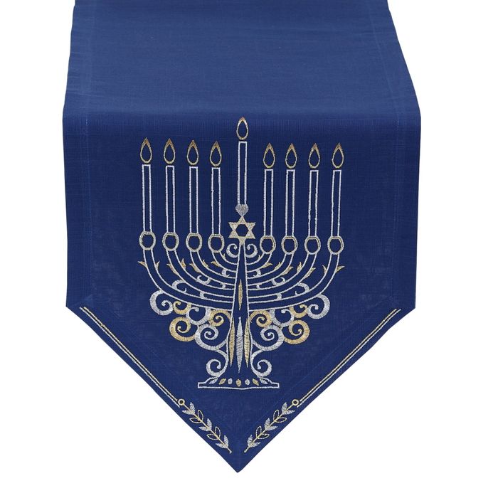 A blue table runner featuring an embroidered menorah at one end.