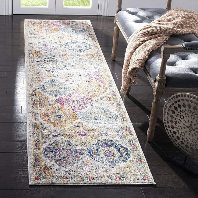 A rectangular runner featuring a colorful diamond pattern and a border, placed on the floor of a cozy home