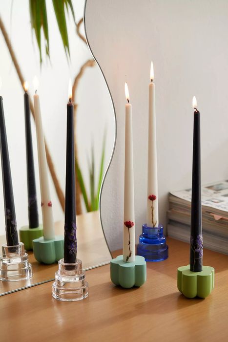 Two black and two white candles elegantly placed in stands, their flames flickering to create a soothing glow.