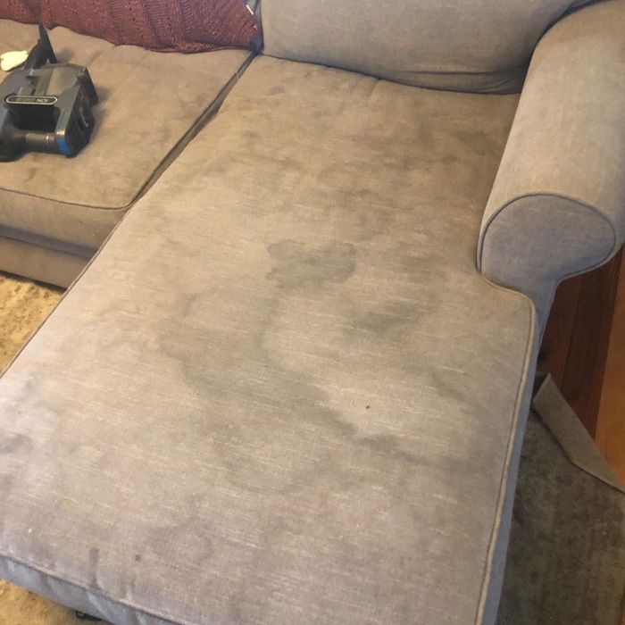 A reviewer's sofa covered in visible stains.
