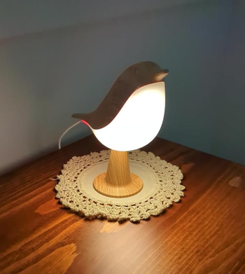A bird-shaped lamp glowing gently with a light-up body.