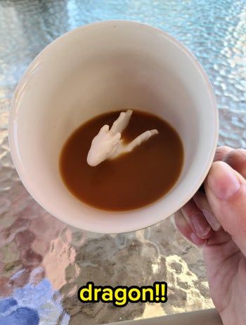 A coffee cup with a horse-shaped stream of cream pouring into the liquid.
