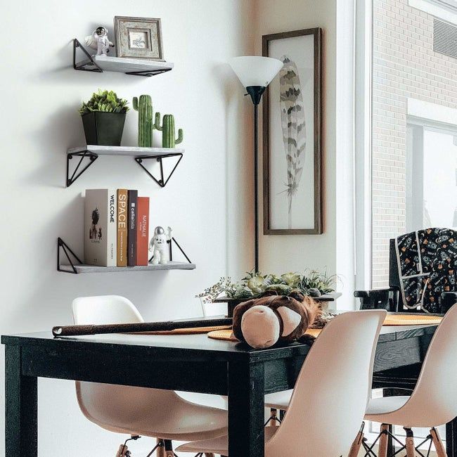 Floating shelves mounted on a wall behind a dining table.
