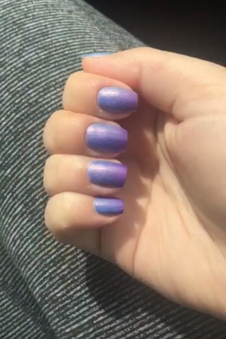 A review photo of the same hand, now showing purple nails