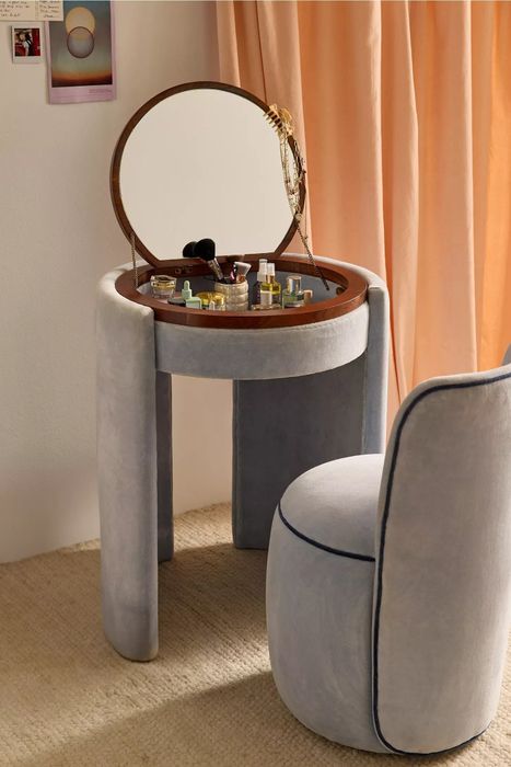 Vanity table featuring a circular mirror, a cushioned chair, and an array of beauty products, elegantly placed in a modern home interior