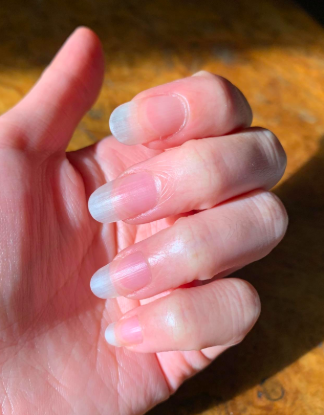 A reviewer’s nails and cuticles looking long and healthy